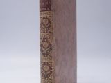an old book sitting on top of a white surface