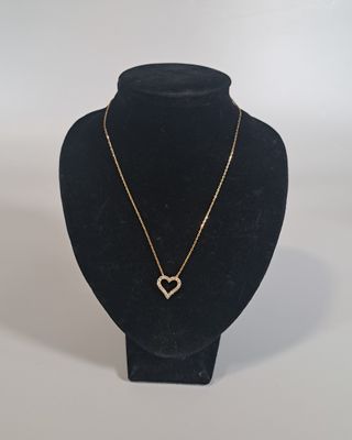 un mannequin noir portant un collier avec un cœur en or