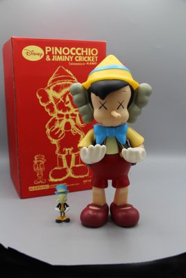 une petite figurine représentant un personnage de dessin animé à côté d'une boîte rouge