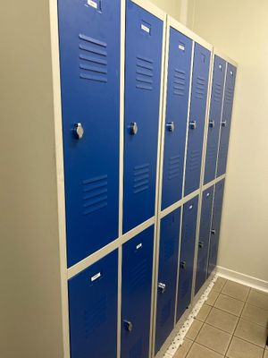 Plusieurs casiers bleus sont alignés les uns à côté des autres dans une salle de bains