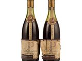two bottles of wine sitting next to each other on a white surface