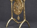 an image of a gold clock sitting on top of a metal stand