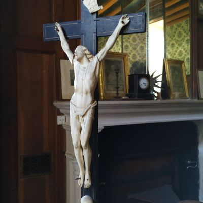 une statue de Jésus sur une croix devant une cheminée