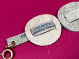 an image of a close up of a key chain on a pink surface