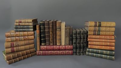 several old books stacked on top of each other on a gray surface