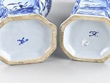 two blue and white vases sitting next to each other