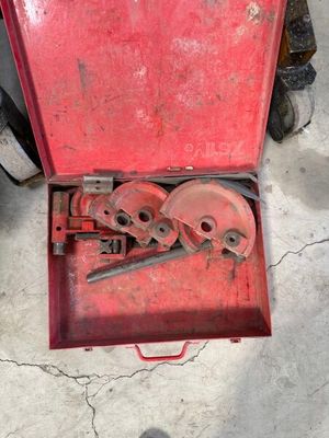 a red tool box with tools in it on the ground
