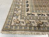un tapis posé à même le sol, sur lequel sont représentés des chevaux