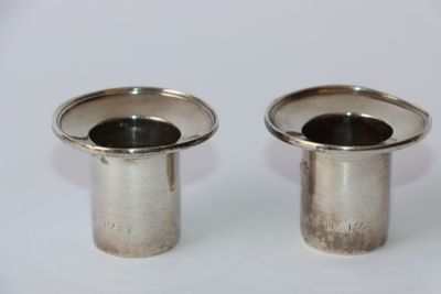 une paire de bougeoirs plaqués argent sur fond blanc