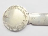 a silver spoon with a silver handle on a white surface