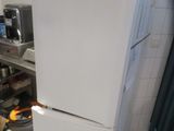 a white refrigerator sitting in a kitchen next to a stove