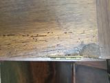 a close up of a wooden table with a drawer underneath it