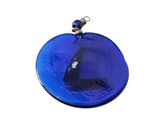 a blue glass ornament hanging on a white wall