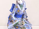 une figurine représentant une femme assise sur une table