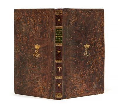 un vieux livre à la couverture brune et à la bordure dorée