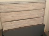 a bed with a wooden headboard on a hard wood floor