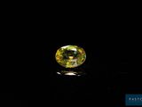 a yellow sapphire stone on a black surface