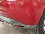 a close up of a red car with a denting on it