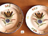 two plates with flowers painted on them on a table