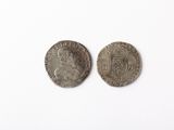 two silver coins on a white surface with a white background