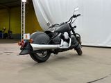 a motorcycle that is parked in front of a white curtain