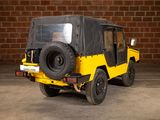a yellow jeep parked in front of a brick wall