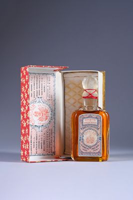 a small bottle of perfume sitting next to a box