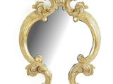 l'image d'un miroir doré sur un mur blanc