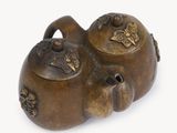 bronze figurine of a cat with a teapot on its back