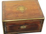 an old wooden box with a gold emblem on the lid