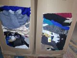 two open cardboard boxes with clothes in them on the floor
