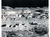 photographie en noir et blanc de la surface de la Lune, avec des rochers et de la neige
