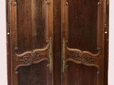 une image représentant une armoire en bois dont les portes sont ornées de sculptures élaborées