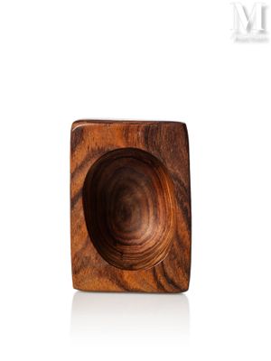 a wooden bowl that is sitting on a white surface