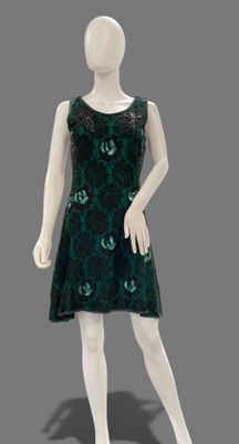 a mannequin dressed in a green dress on a gray background