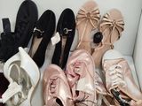 several pairs of women ' s shoes are lined up on a white chair
