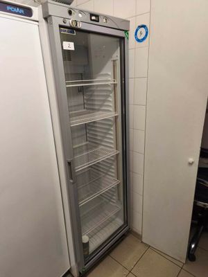 an empty refrigerator in the corner of a room