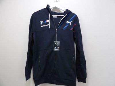 une veste bleue arborant le logo BMW, accrochée au mur