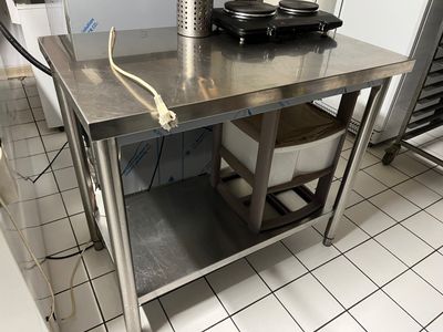 a stainless steel table in a kitchen with a frying pan on it