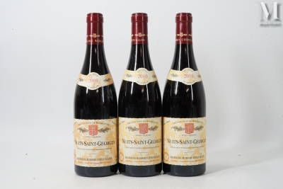 trois bouteilles de vin rouge sont alignées sur une surface blanche