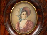 portrait d'une dame portant un bonnet bleu et une robe rose, dans un cadre en bois