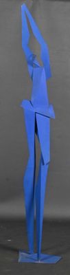 a blue paper sculpture of a woman standing on a base