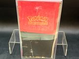 a clear box with a red lid on a black surface