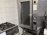 a man standing in a kitchen next to a large oven