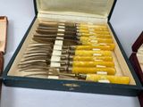 many knives in a box on a table next to a box of other knives