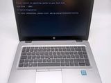 a laptop with a blue screen on a white table