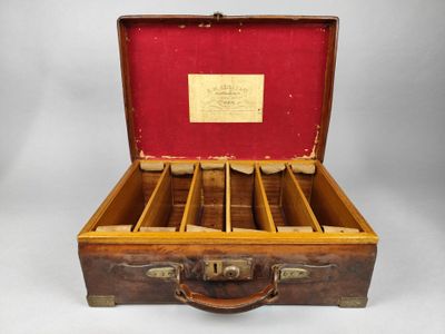 a wooden case with six compartments and a red lining