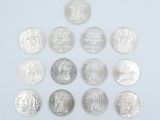 several different coins are arranged in a triangle on a white surface