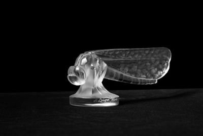 black and white photograph of a glass object on a black surface