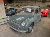 an old car parked in a garage with other cars in the background